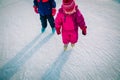 Little girls skating together in snow, kids winter activities Royalty Free Stock Photo