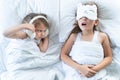 Little girls sleep in bed. One is snoring hard,sister is plugging ears with fur headphones.Early morning wake up,rise to Royalty Free Stock Photo