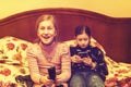 Little girls with smartphone watch TV. The girl in front of the TV looking in the smartphone. toned