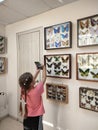 little girls take pictures on a mobile phone exhibits in the insectarium.