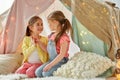 Little girls talking in kids tent at home
