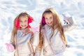 Little girls throw snowball in park. Portrait of two little girls play with snow in winter. Cute sisters playing in a Royalty Free Stock Photo