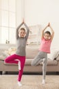Little girls training yoga in tree pose together indoors Royalty Free Stock Photo