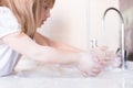 Little girls wash their hands in the sink with soap in the foam. Protection against coronovirus covid-2019 using personal hygiene Royalty Free Stock Photo