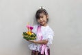 Little girls wearing traditional costume thai style holding a krathong  with a bright smile. Royalty Free Stock Photo