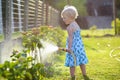 Little giving water to flowers in the garden