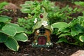 Little gnome cottage among hostas in a shade garden Royalty Free Stock Photo