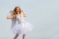 Little goddess with white wings alone on blue sky background. Teenager happy angel. Portrait of little curly blond Angel Royalty Free Stock Photo