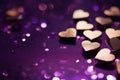 Little gold hearts scattered on a purple background with copy space.