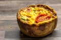 Little gourmet tomato and egg custard tartlet isolated on brown kitchen work top - savoury small quiche background Royalty Free Stock Photo