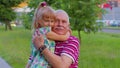 Little granddaughter child embracing kissing with her grandfather in park, happy family relationship Royalty Free Stock Photo