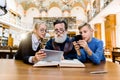 Little granddaughter and grandson teach senior elderly grandfather to surf internet using modern technologies, digital