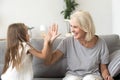 Little granddaughter and happy grandmother giving high five play