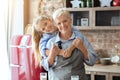 Little granddaughter hugging her happy grandmother at home kitchen Royalty Free Stock Photo