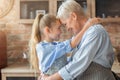 Little granddaughter hugging her happy grandmother in kitchen Royalty Free Stock Photo