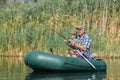 grandfather with grandson together fishing from inflatable boat Royalty Free Stock Photo