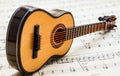 Little guitar lying on sheet music 5 Royalty Free Stock Photo