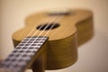 Little guitar. Ukulele made of wood. Musical instrument for extracting sounds. String instrument with fretboard and deck Royalty Free Stock Photo