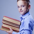 Little guy with pile of books as symbol of learning, knowledge a Royalty Free Stock Photo