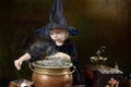Little halloween witch with cauldron