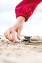 Little Hand placing Stone on the Pyramid on sand. Sea in the bac Royalty Free Stock Photo
