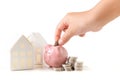 Little hand putting coin to piggy bank, saving money for buy new house Royalty Free Stock Photo