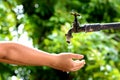 Little hand wait for water drop from faucet Royalty Free Stock Photo