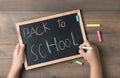 Little hand writing back to school on black chalk board Royalty Free Stock Photo