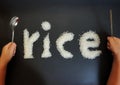 The little hands of Asian boy pretent to use a spoon and chopstices toeat rice Royalty Free Stock Photo