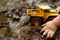 little hands pushing a toy dump truck through mud Royalty Free Stock Photo