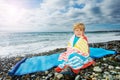 Little handsome boy sit wrapped in beach towel over the sea Royalty Free Stock Photo