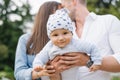 Little happy baby in the arms of loving parents in the summer in the park Royalty Free Stock Photo