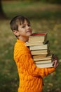 Little happy boy carrying stack of books Royalty Free Stock Photo