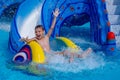 Little happy boy with hands up sliding into water in aqua park Royalty Free Stock Photo