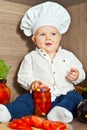 Little happy boy kid play in chef at kitchen and cook food Royalty Free Stock Photo