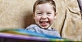 Little happy boy laughing while sitting on the couch. close up Royalty Free Stock Photo