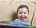 Little happy boy laughing while sitting on the couch . close up Royalty Free Stock Photo