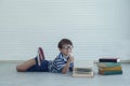 Little happy Caucasian boy lying and reading text book Royalty Free Stock Photo