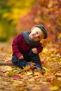 Little happy child boy sits in park on background of colorful au Royalty Free Stock Photo