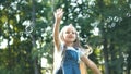 Little happy child girl cathing and bursting soap bubbles outdoors in summer