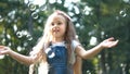 Little happy child girl cathing and bursting soap bubbles outdoors in summer