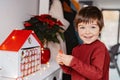 Little happy child opening first day in handmade advent calendar made from toilet paper rolls.