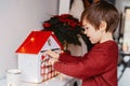 Little happy child opening first day in handmade advent calendar.