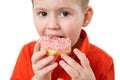 Little happy cute boy is eating donut on white background wall. child is having fun with donut. Tasty food for kids