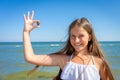 Little happy cute girl on the beach holding heart-shaped sea stone in hands Royalty Free Stock Photo