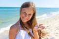 Little happy cute girl on the beach holding heart-shaped sea stone in hands Royalty Free Stock Photo