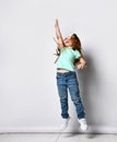 Little happy fitness girl child jumping stretching arm up studio shot Royalty Free Stock Photo