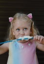 Little happy funny girl eating cotton candy playing around in amusement park Royalty Free Stock Photo