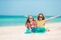 Little happy funny girls have a lot of fun at tropical beach playing together.