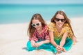 Little happy funny girls have a lot of fun at tropical beach playing together.